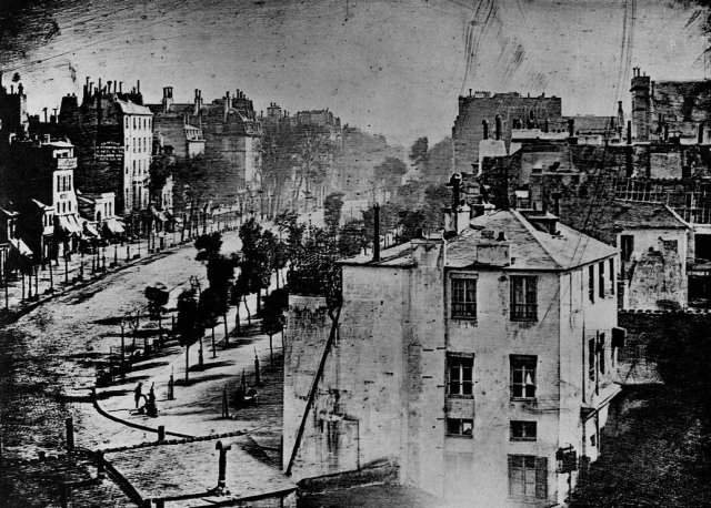 This is the "View of the Boulevard du Temple", the first ever reliably dated photograph of a person. The photo was taken by Louis Daguerre (French, 1787-1851) in late 1838 or early 1839 in Pari
