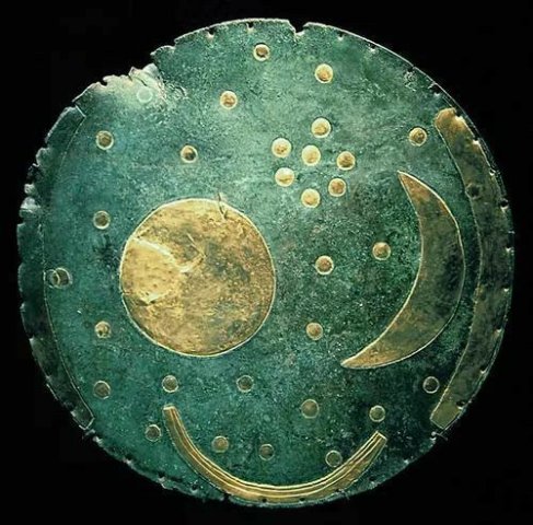 The Nebra Sky Disk.
The symbols are interpreted generally as the Sun or full moon, a lunar crescent, and stars (including a cluster of seven interpreted as the Pleiades).
The disk is attribu